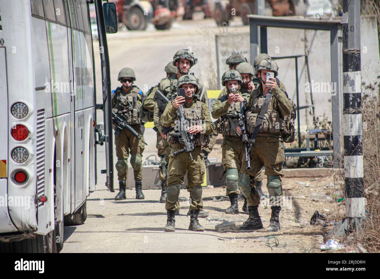 I soldati israeliani registrano con i loro telefoni mentre stanno di guardia nella città di Hawara, vicino al sito di sparatoria dei due coloni israeliani, durante intense ricerche per l'aggressore, a sud della città di Nablus. Due coloni ebrei sono stati uccisi in un attacco di fuoco palestinese sabato in Cisgiordania, l'esercito israeliano ha detto che l'ultima esplosione di violenza è quella di scopare la regione. E cercherà sospetti e blocchi stradali vicino alla città di Hawara, un'area instabile nella Cisgiordania settentrionale. (Foto di Nasser Ishtayeh/SOPA Images/Sipa USA) Foto Stock