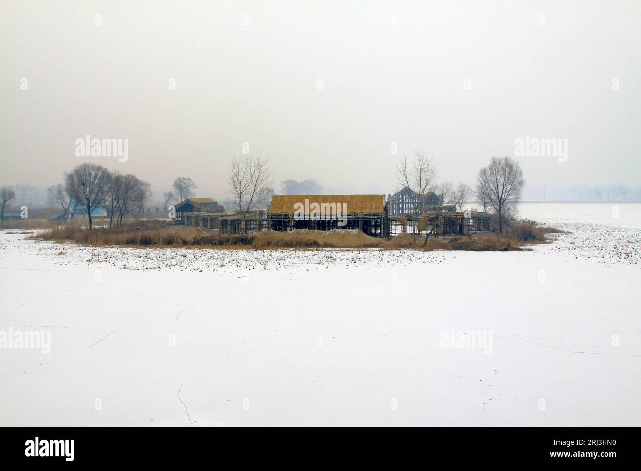 edificio incompiuto nella neve sotto un cielo nuvoloso Foto Stock