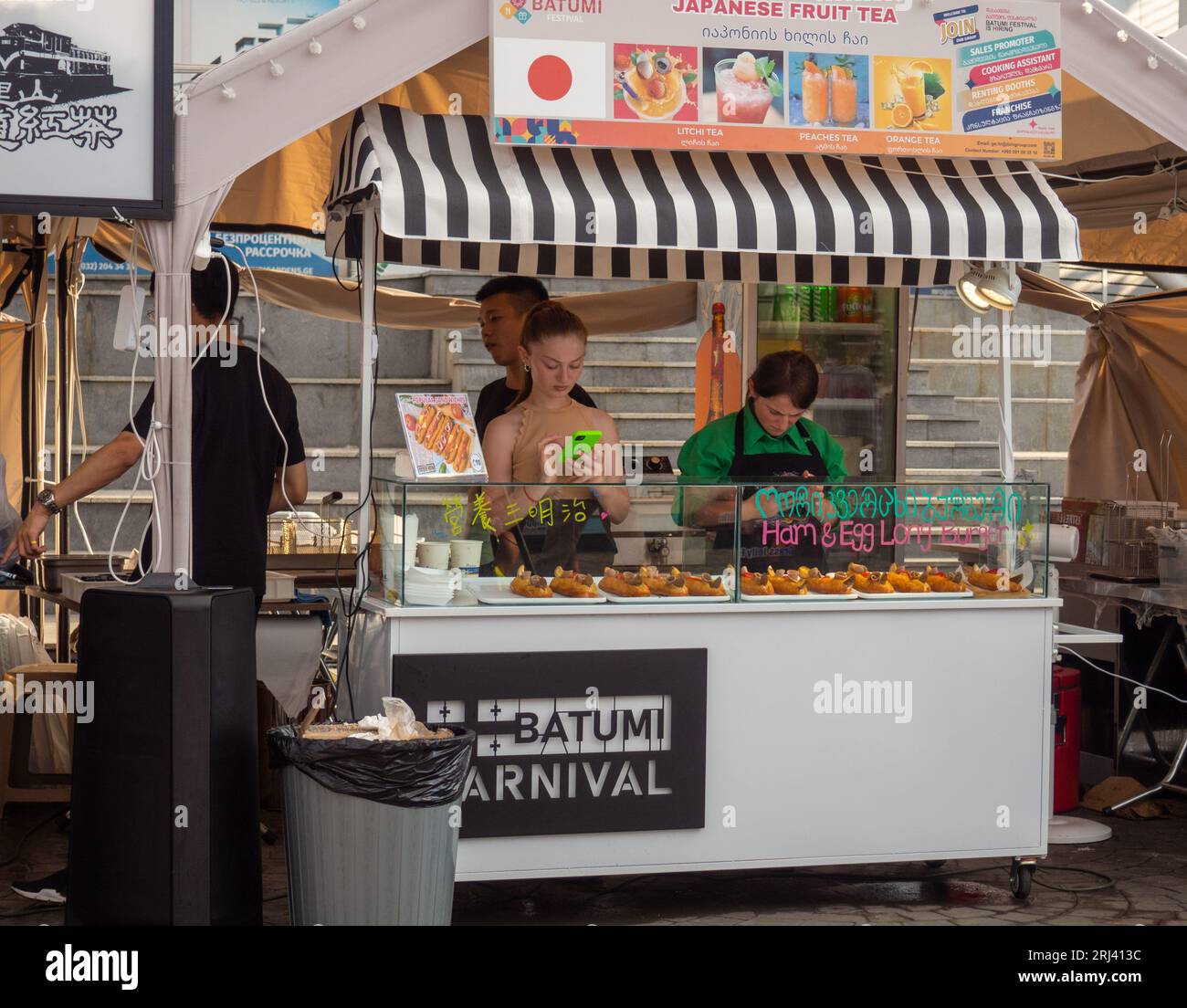 Batumi, Georgia. 08.13.2023 bancarelle alimentari al festival. Cucine da tutto il mondo. Cibo fresco all'aperto. Ristorante con tende mobili. Foto Stock