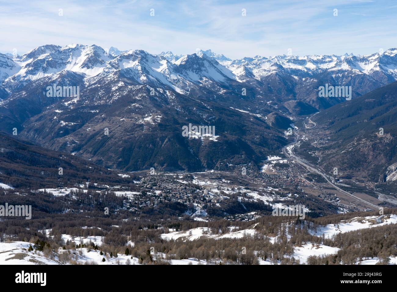 Vista della città di Oulx tra le montagne (Valle di Susa, Piemonte, Alpi italiane) in inverno con la neve. Foto Stock