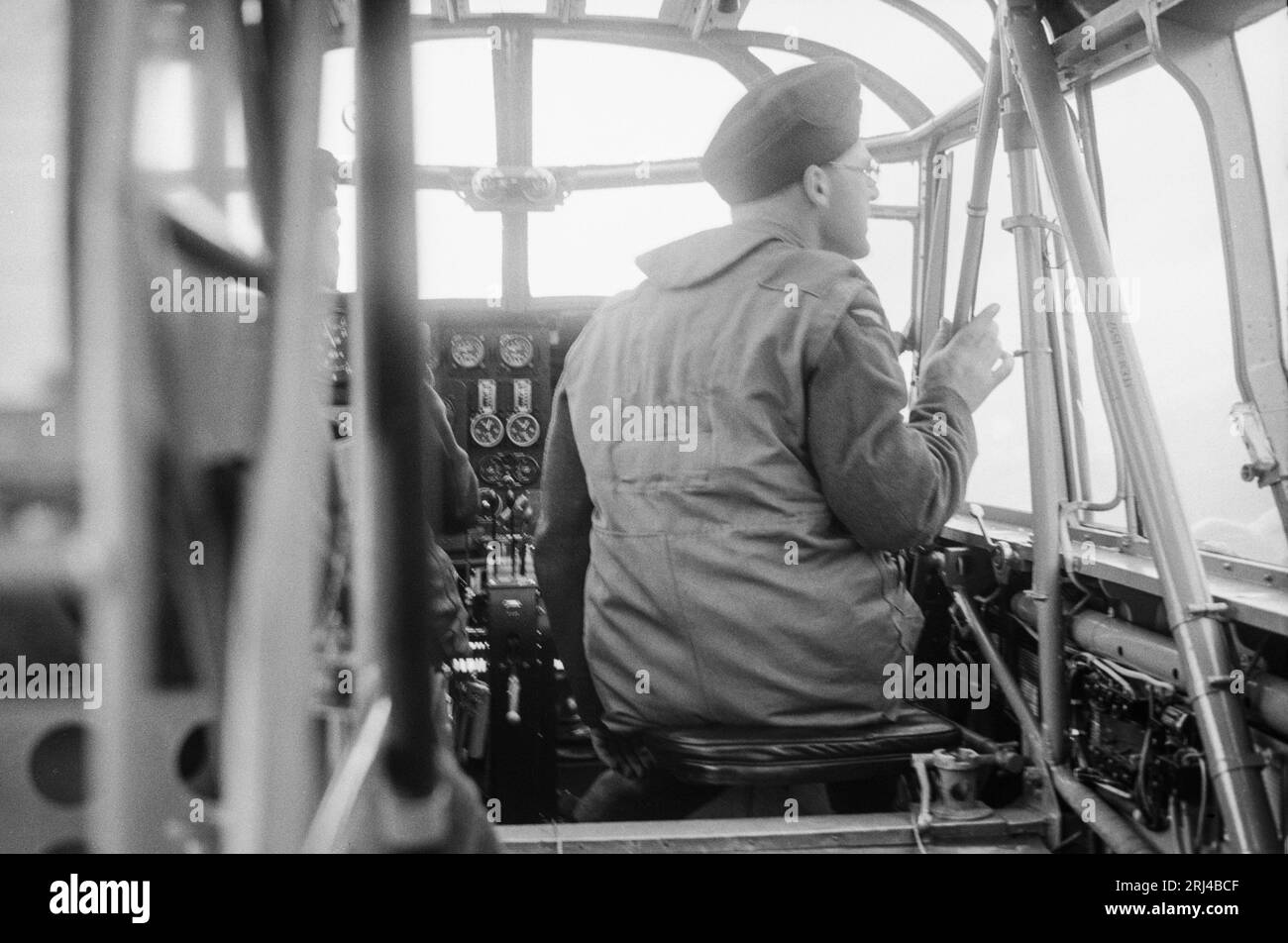 Una fotografia in bianco e nero degli anni '1930 che mostra un aviatore della Royal Air Force, in posa per la macchina fotografica, mentre vola su un aereo militare. Foto Stock