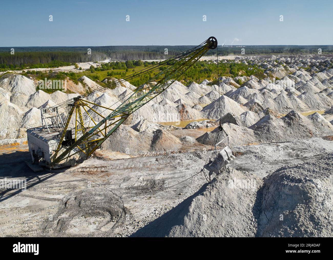 Il dragline a piedi con paranco e benna lavora in cava di pietra Foto Stock