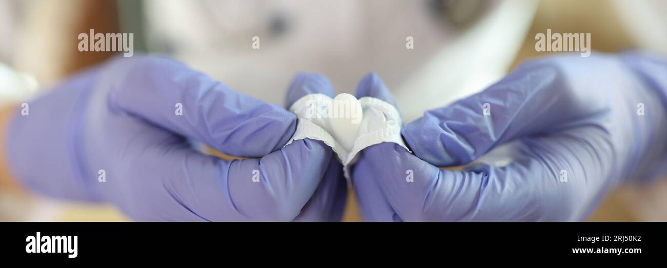 Primo piano delle mani del medico in guanti supposte aperte per uso anale o vaginale. Foto Stock