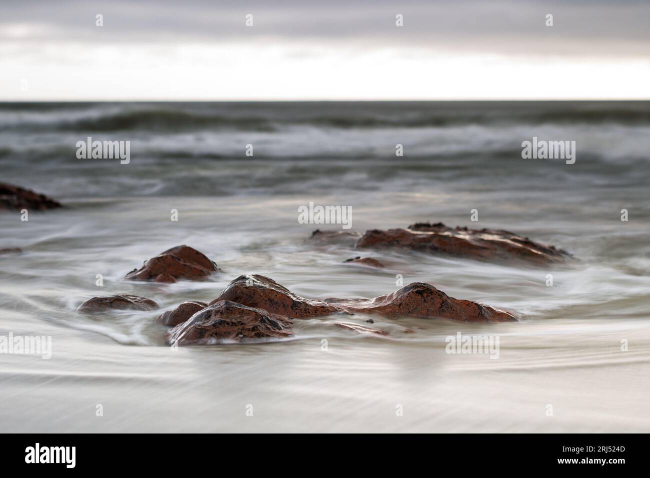 Onde che si infrangono sulle rocce diaframma lento foto di paesaggi inclinati e spostati Foto Stock