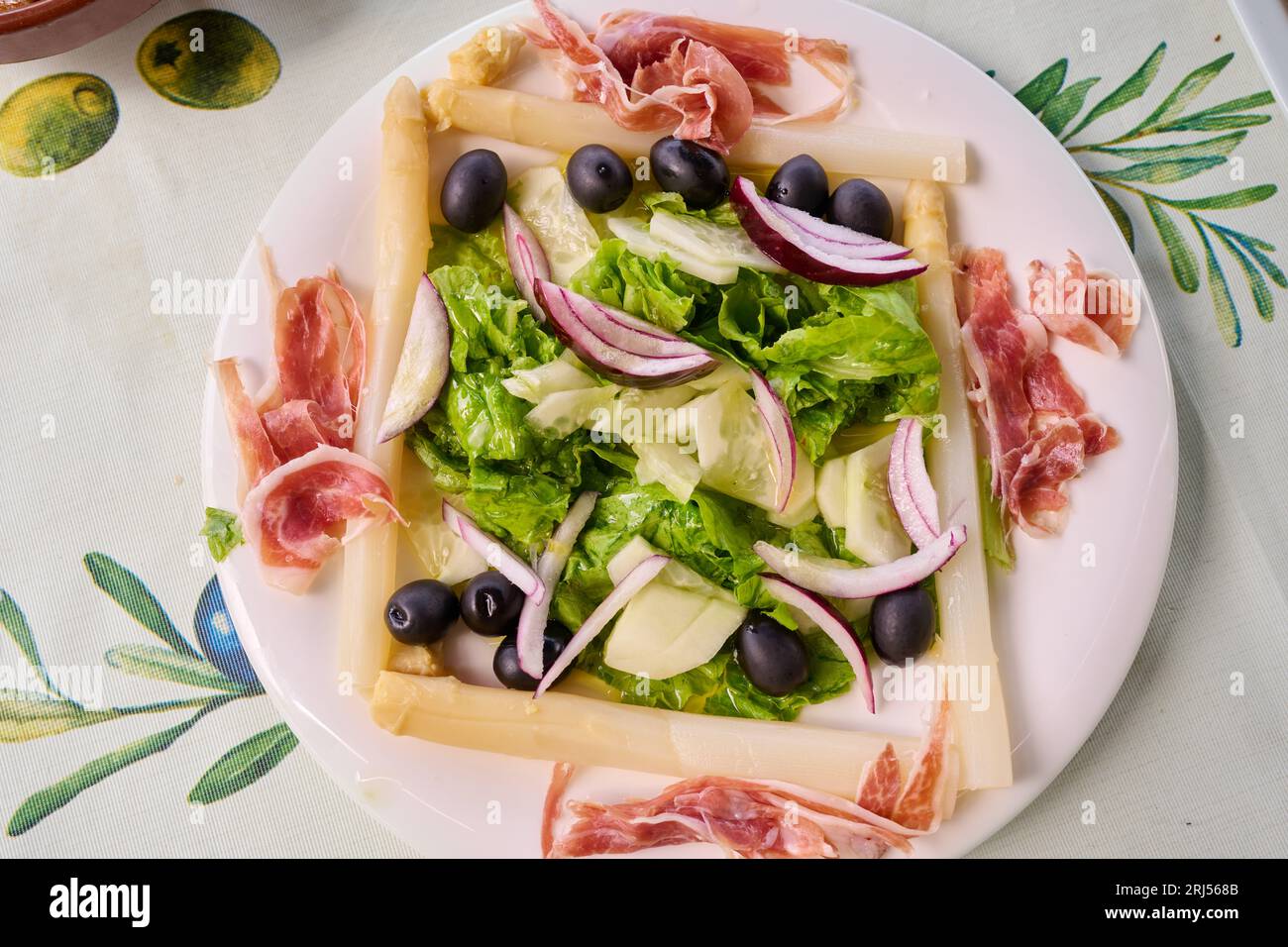 Insalata di lattuga, asparagi, olive nere, prosciutto iberico, cetriolo e cipolla Foto Stock