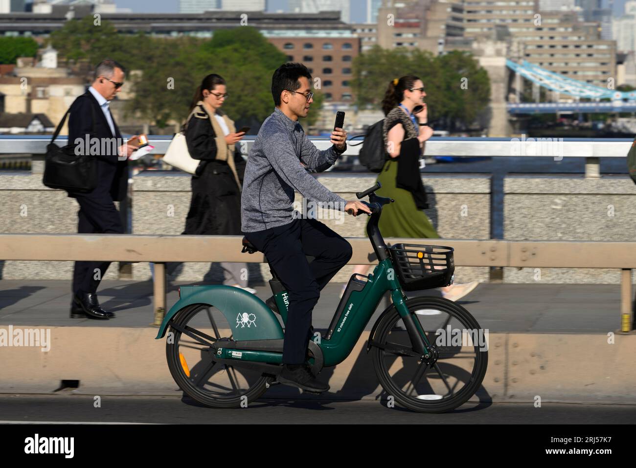 Un uomo che viaggia su una bicicletta elettrica HumanForest attraverso il London Bridge, durante l'ora di punta. London Bridge, Londra, Regno Unito. 7 giugno 2023 Foto Stock
