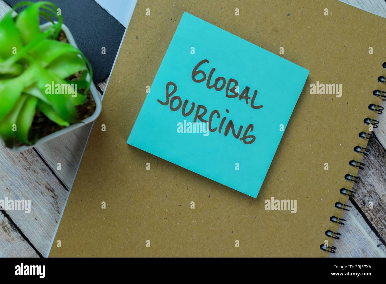 Concetto di Global Sourcing scrivere sulle note adesive isolate su un tavolo in legno. Foto Stock
