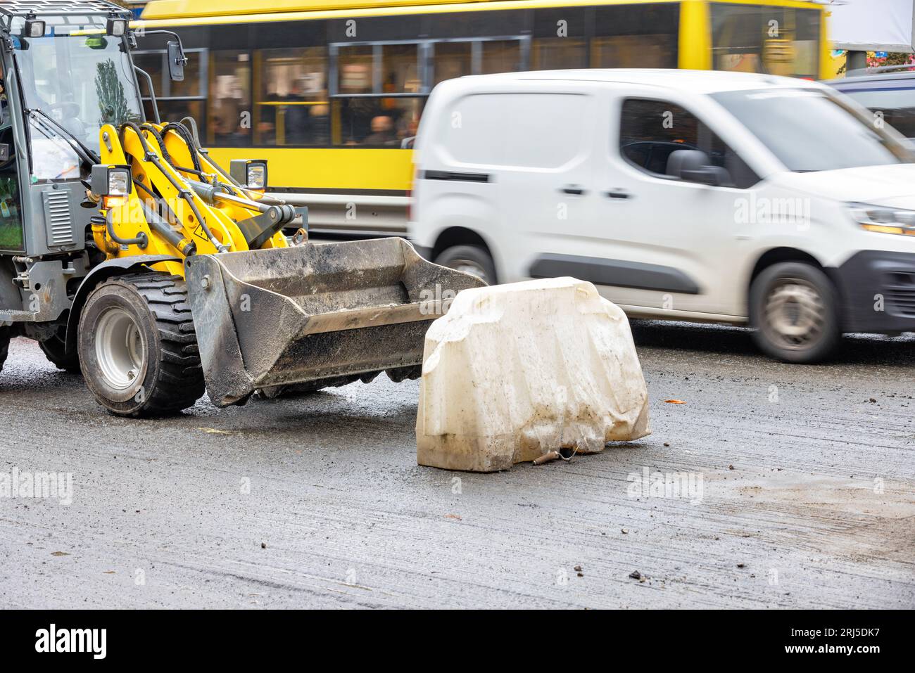 Un trattore stradale è parcheggiato sul bordo della strada sullo sfondo del trasporto urbano. Foto Stock