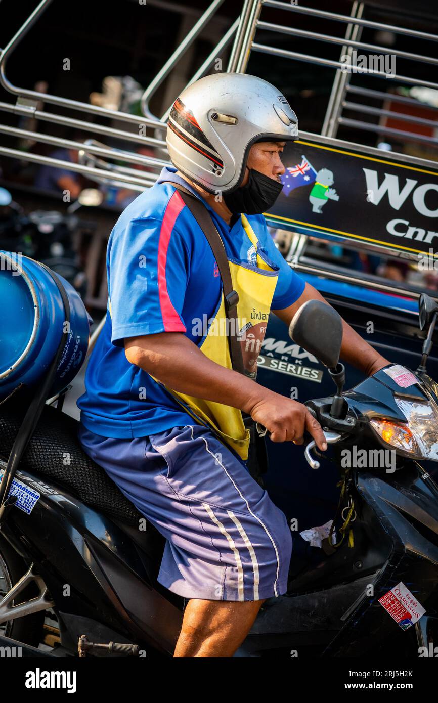 Un uomo tailandese corre lungo Soi Buakhao, Pattaya, Thailandia sulla sua moto. Foto Stock