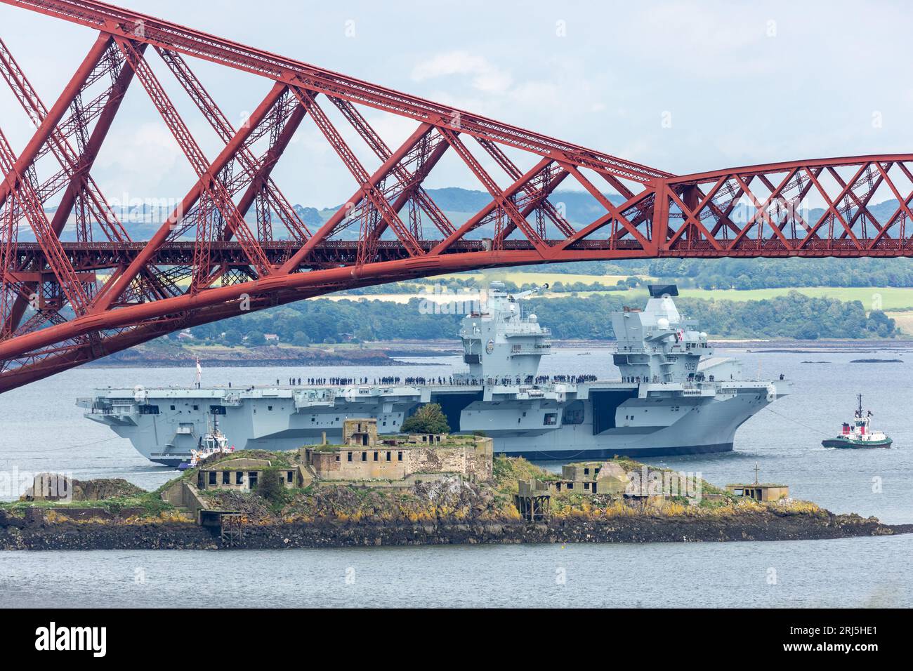 Portaerei HMS Prince of Wales che lascia il porto di Rosyth e naviga sotto il Forth Bridge Foto Stock