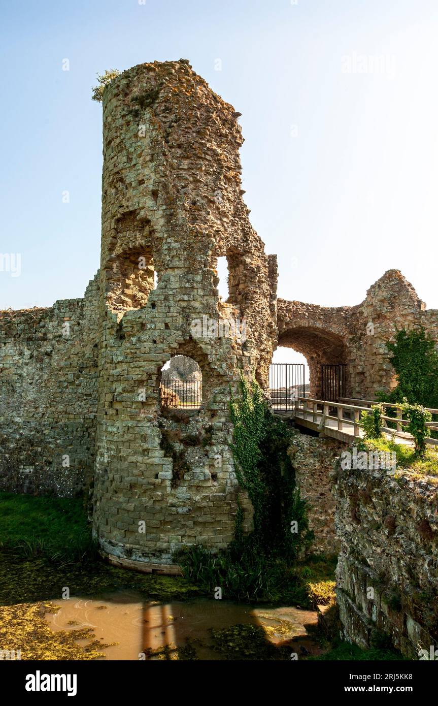 Le rovine del castello di Pevensey sono raggiunte attraversando un ponte di legno sopra il fossato Foto Stock