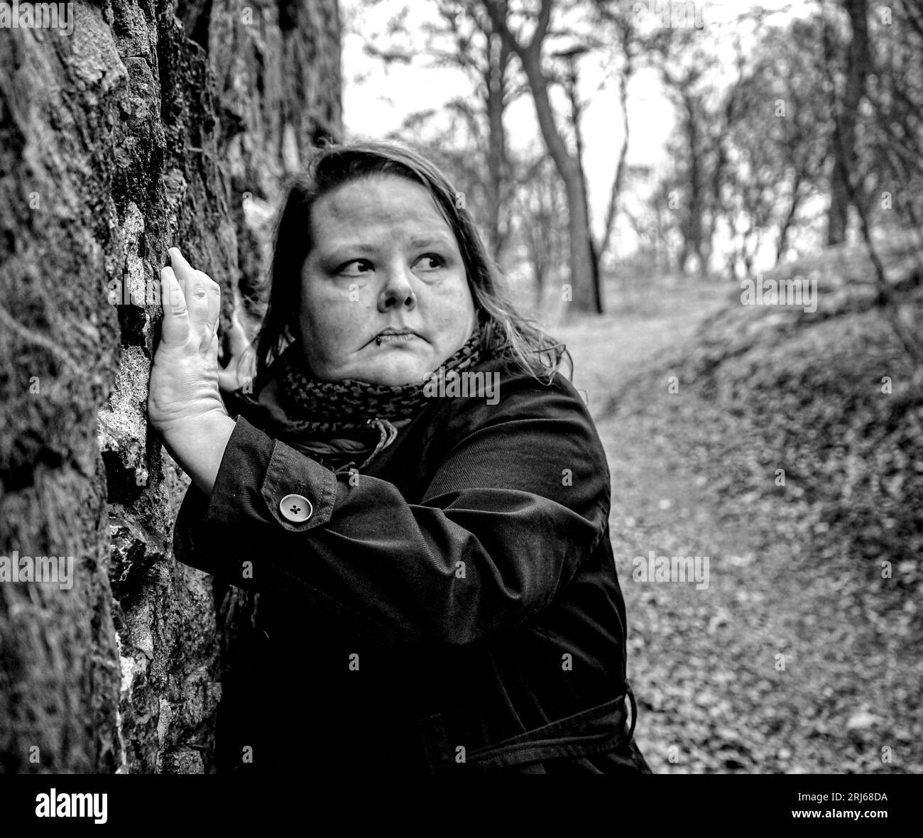 Ritratto di una persona in piedi contro un muro di pietra Foto Stock