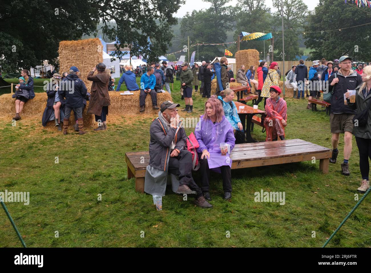 Persone sedute sotto la pioggia al festival Green Man, 2023 Foto Stock