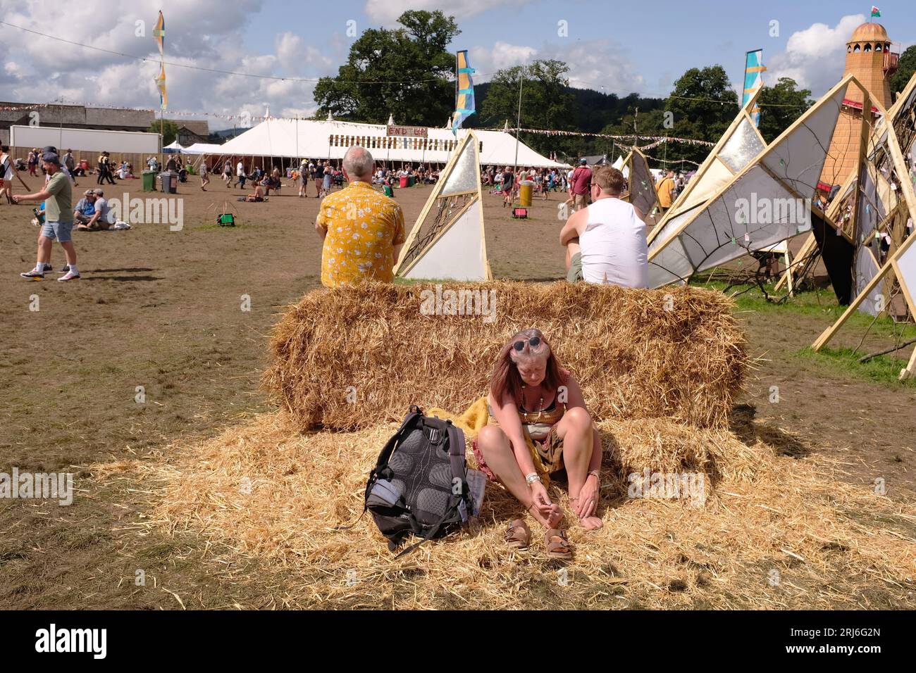 Una donna che riposa al sole a un festival. Foto Stock
