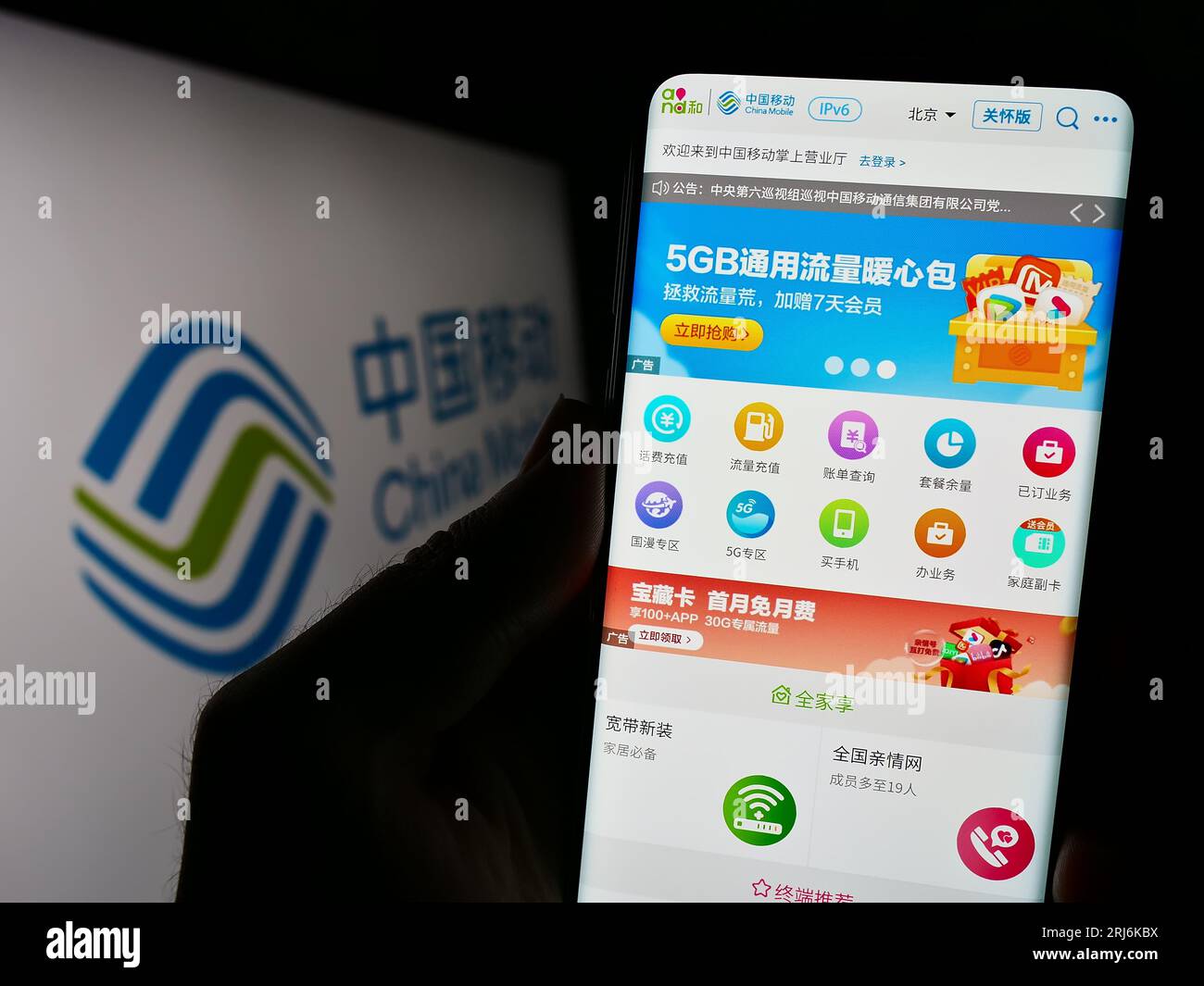 Persona che possiede il cellulare con pagina Web della società di telecomunicazioni China Mobile Limited sullo schermo con logo. Concentrarsi sul centro del display del telefono. Foto Stock