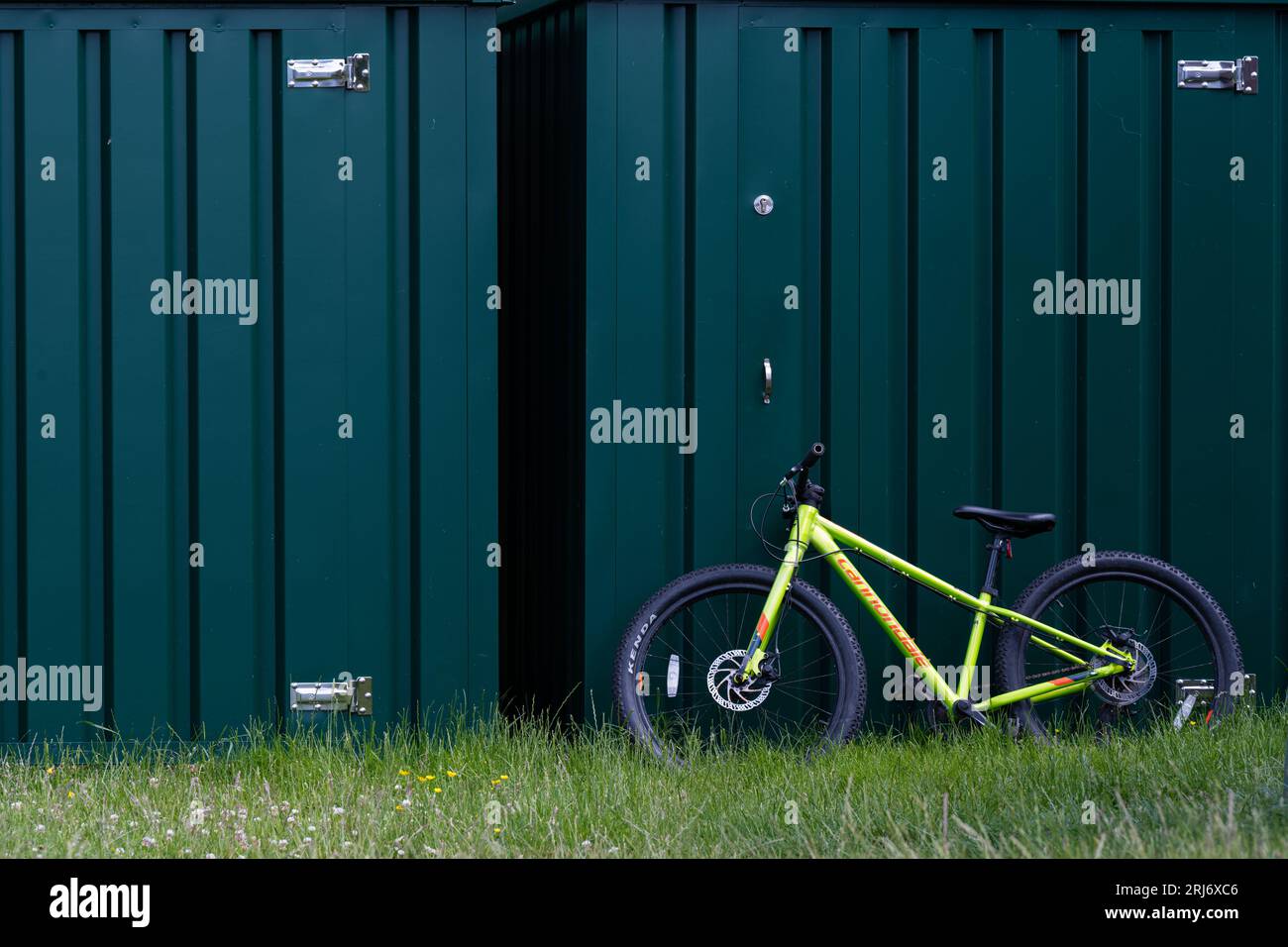 Una mountain bike per bambini si appoggia contro alcuni container Foto Stock