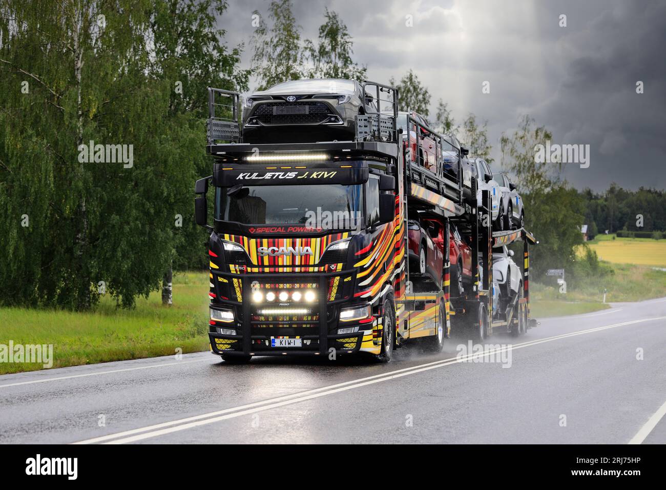 Esclusivo veicolo portante Scania R650 di Kuljetus J. Kivi trasporta nuove auto su strada 52, abbaglianti accesi brevemente. Salo, Finlandia. 20 luglio 2023. Foto Stock