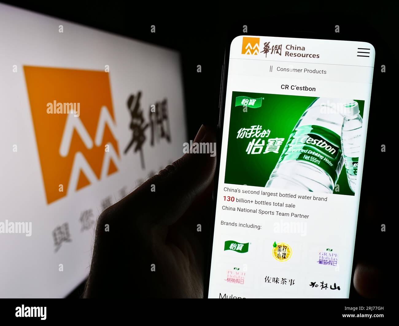 Persona che possiede uno smartphone con il sito Web di China Resources Holdings Company Limited (CRC) sullo schermo con logo. Concentrarsi sul centro del display del telefono. Foto Stock