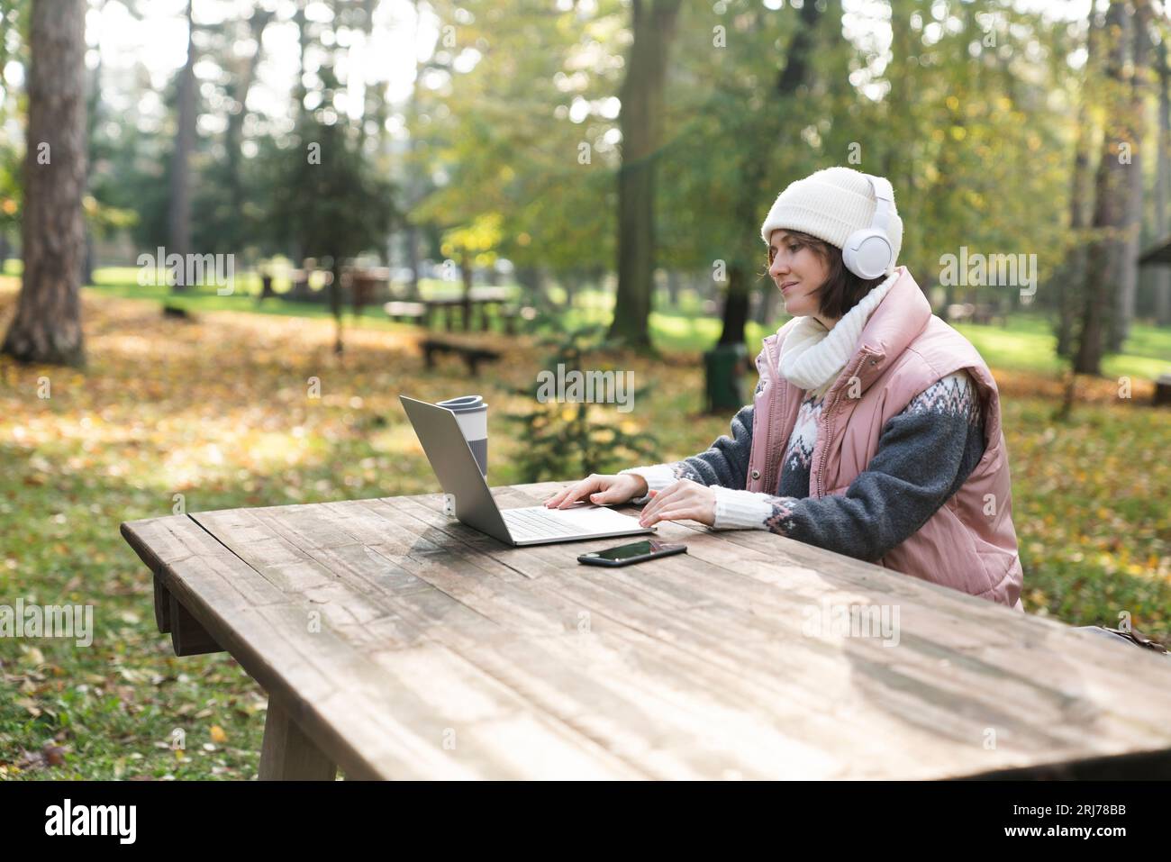 Freelance che lavora su un notebook nel parco autunnale. Foto Stock
