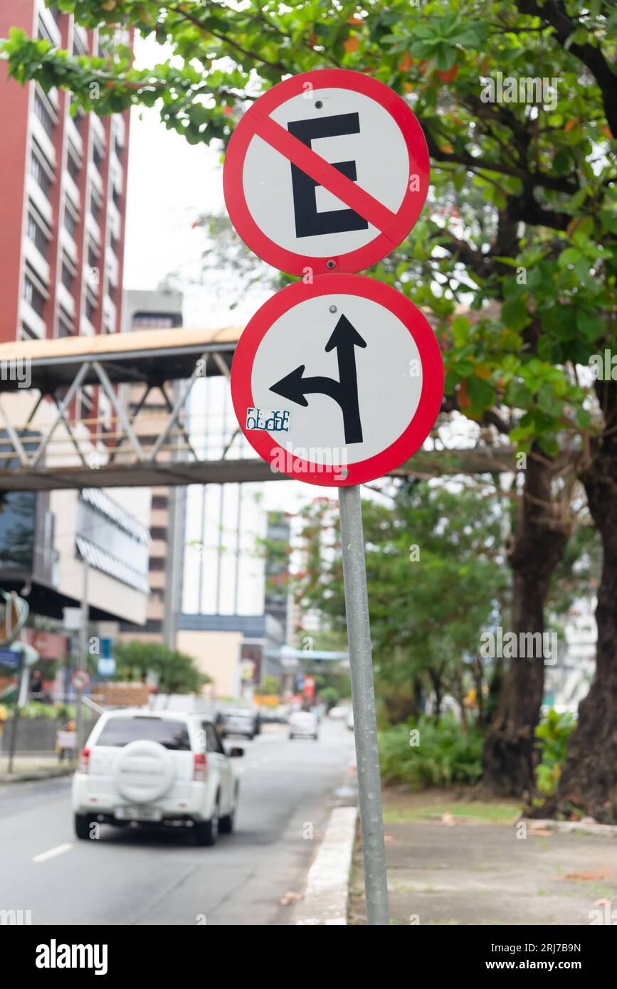 Salvador, Bahia, Brasile - 11 agosto 2023: Un segnale stradale che indica che è vietato fermarsi e un altro che ti informa di girare a sinistra e andare Foto Stock