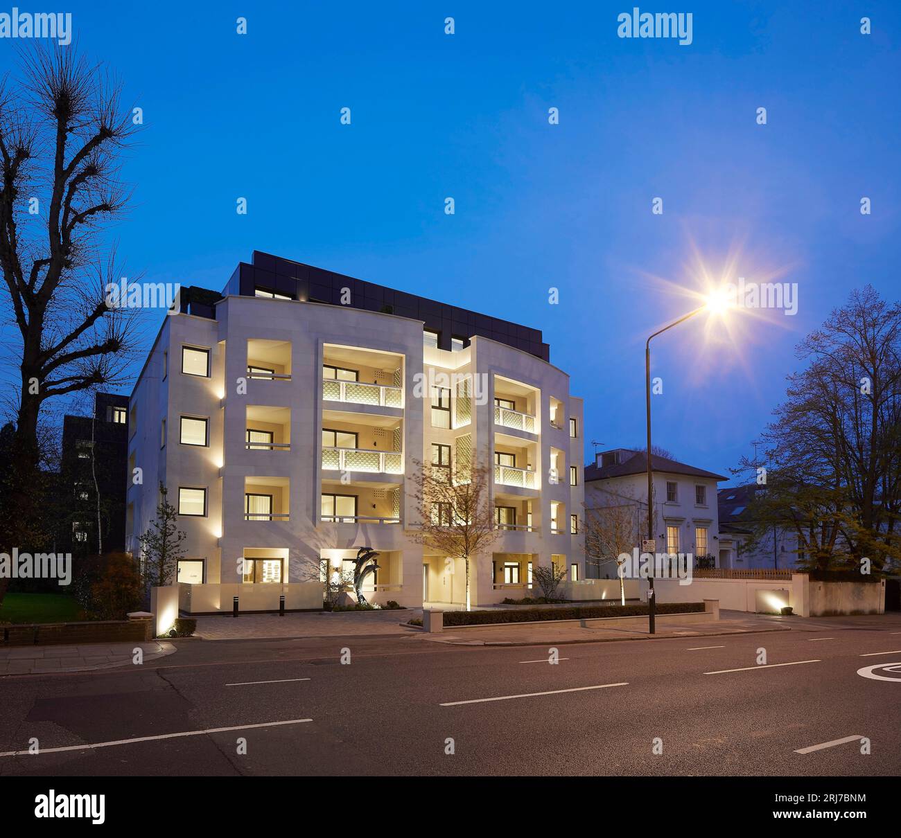 Vista notturna obliqua dall'altra parte della strada. Wellington Road, Londra, Regno Unito. Architetto: Alan Power Architects Ltd, 2022. Foto Stock