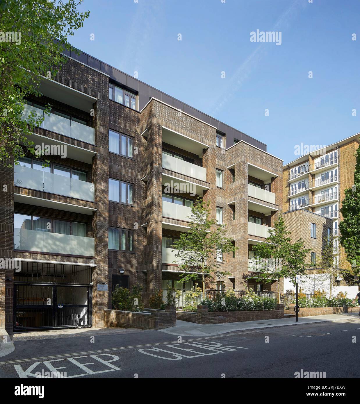 Edificio con vista obliqua con ingresso al parcheggio nel seminterrato. Wellington Road, Londra, Regno Unito. Architetto: Alan Power Architects Ltd, 2022. Foto Stock