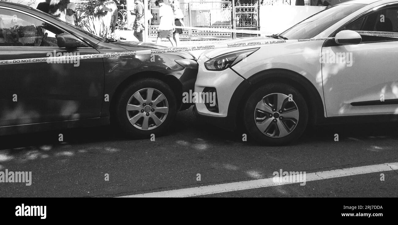 due auto bianche e nere si sono schiantate frontali sulla strada, il nero è nella corsia di avvicinamento Foto Stock