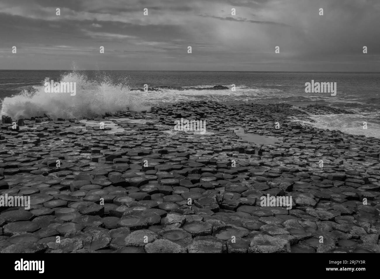 Onde che si infrangono sul Selciato del gigante, contea di Antrim, Irlanda del Nord Foto Stock