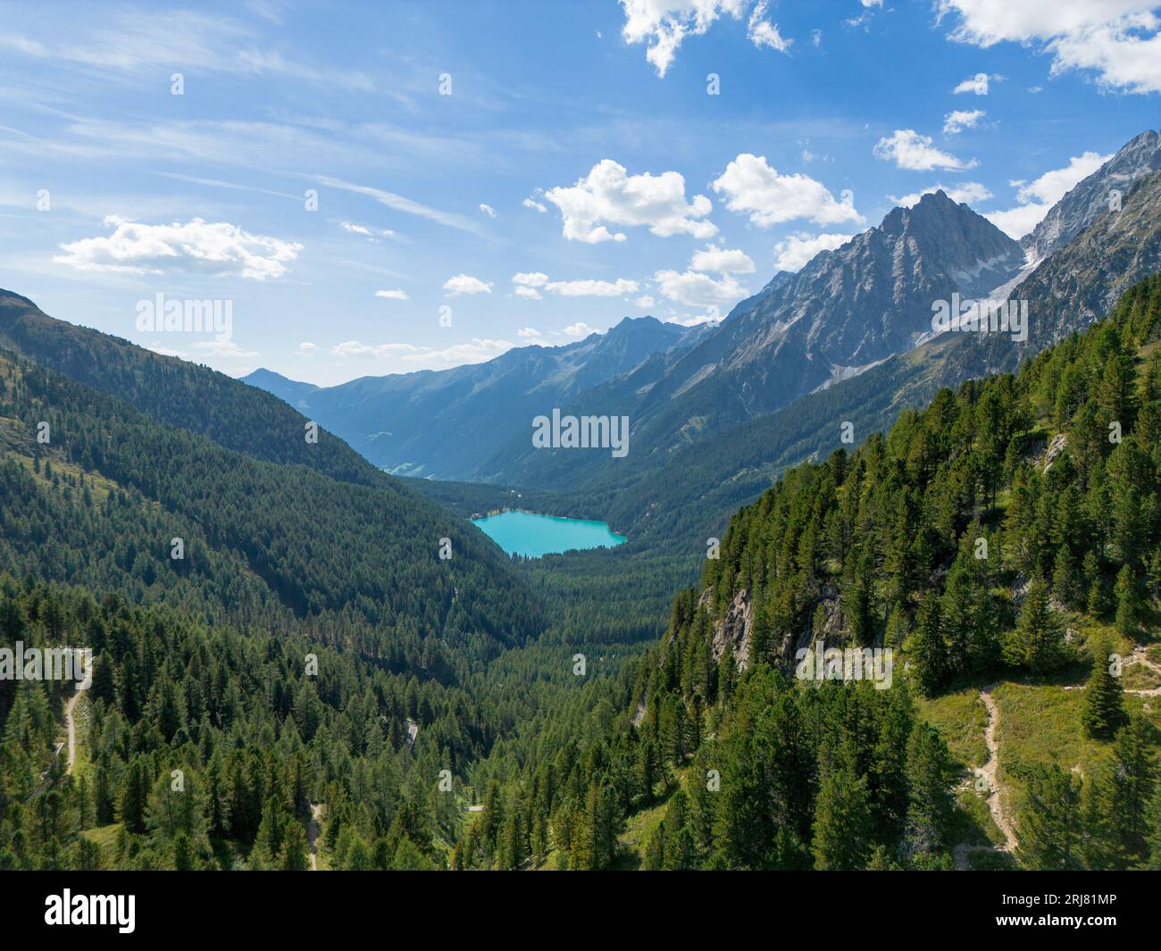 Veduta aerea del lago alpino di Anterselva (vedi Anterselva) vista dal passo Stalle in una valle dolomitica con pino verde Foto Stock