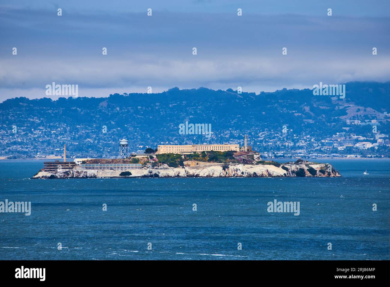 Cielo blu nebbioso sopra ingrandito in vista dell'intera isola di Alcatraz con la città sullo sfondo Foto Stock