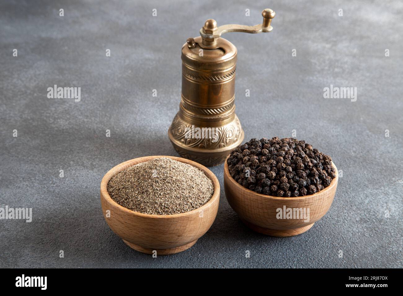 Grani di pepe nero, pepe nero macinato e mulino per metalli, vista dall'alto Foto Stock