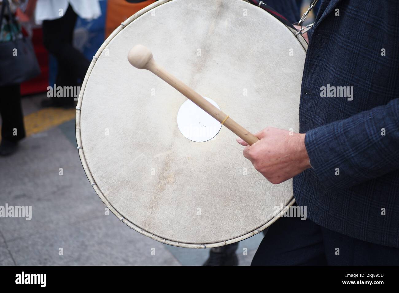 Un uomo ha colpito l'antico tamburo con Musical Instrument. Foto Stock