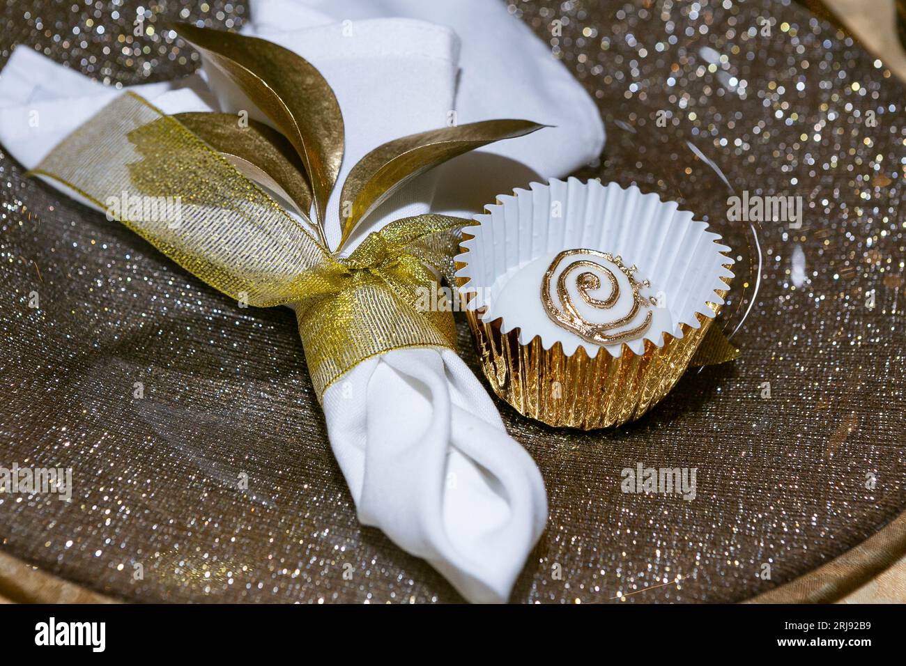 Primo piano di un posto al tavolo per un ospite alla festa; tovagliolo selettivo e dolce. Foto Stock