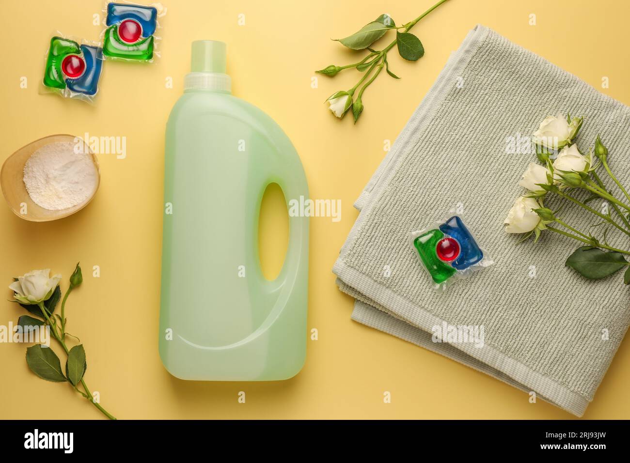 Composizione piatta con flaconi di addolcitore in tessuto su sfondo giallo pallido Foto Stock