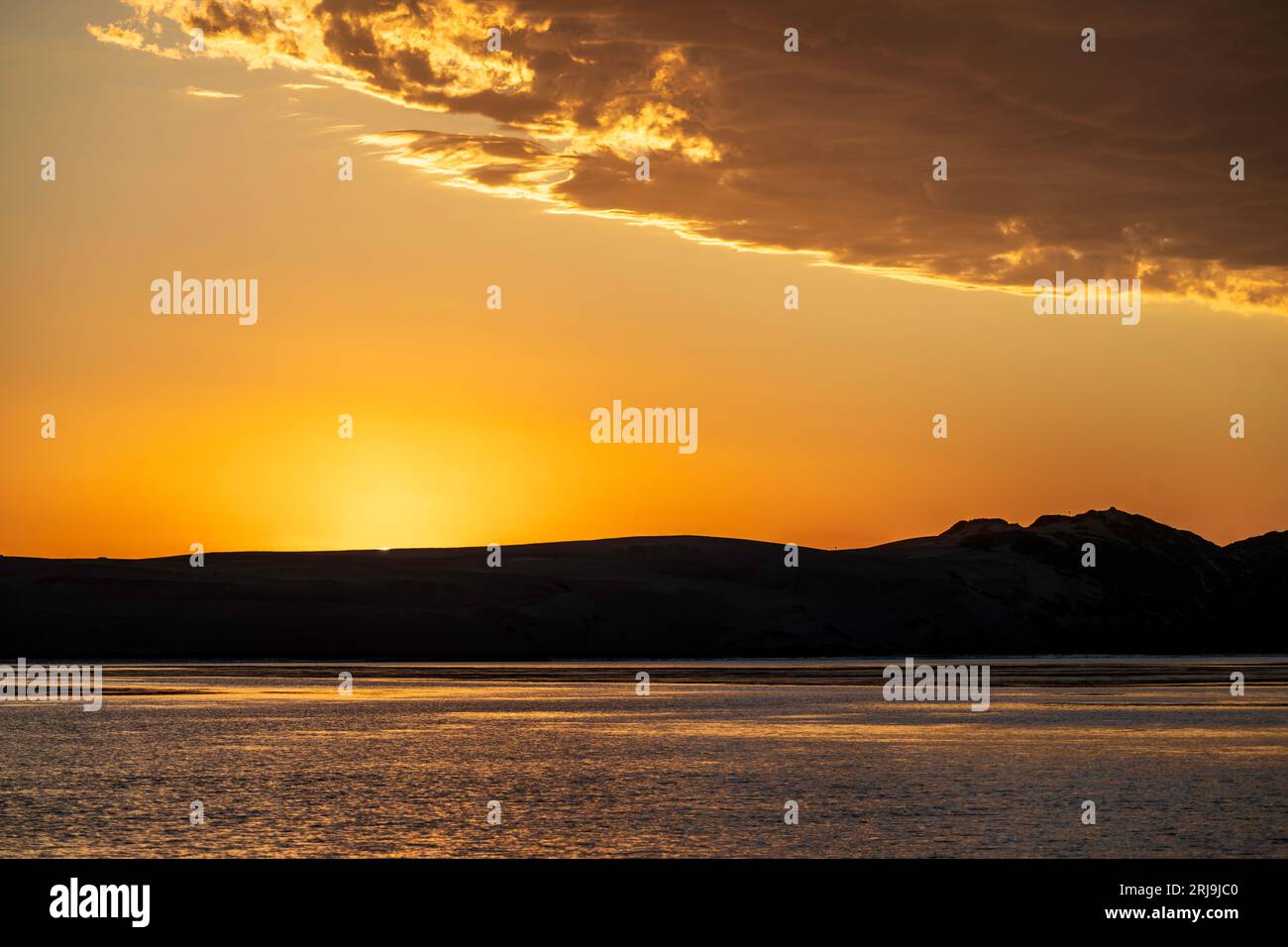 Tramonto sulla sabbia che separa Morro Bay dall'Oceano Pacifico Foto Stock