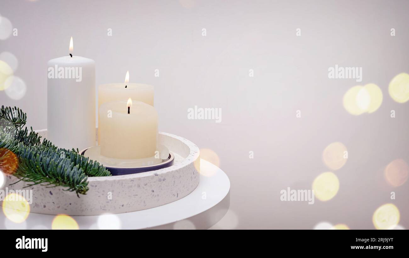 Striscione con candele bianche, rami verdi e luci sfocate, composizione natalizia minimalista, sfondo festivo Foto Stock