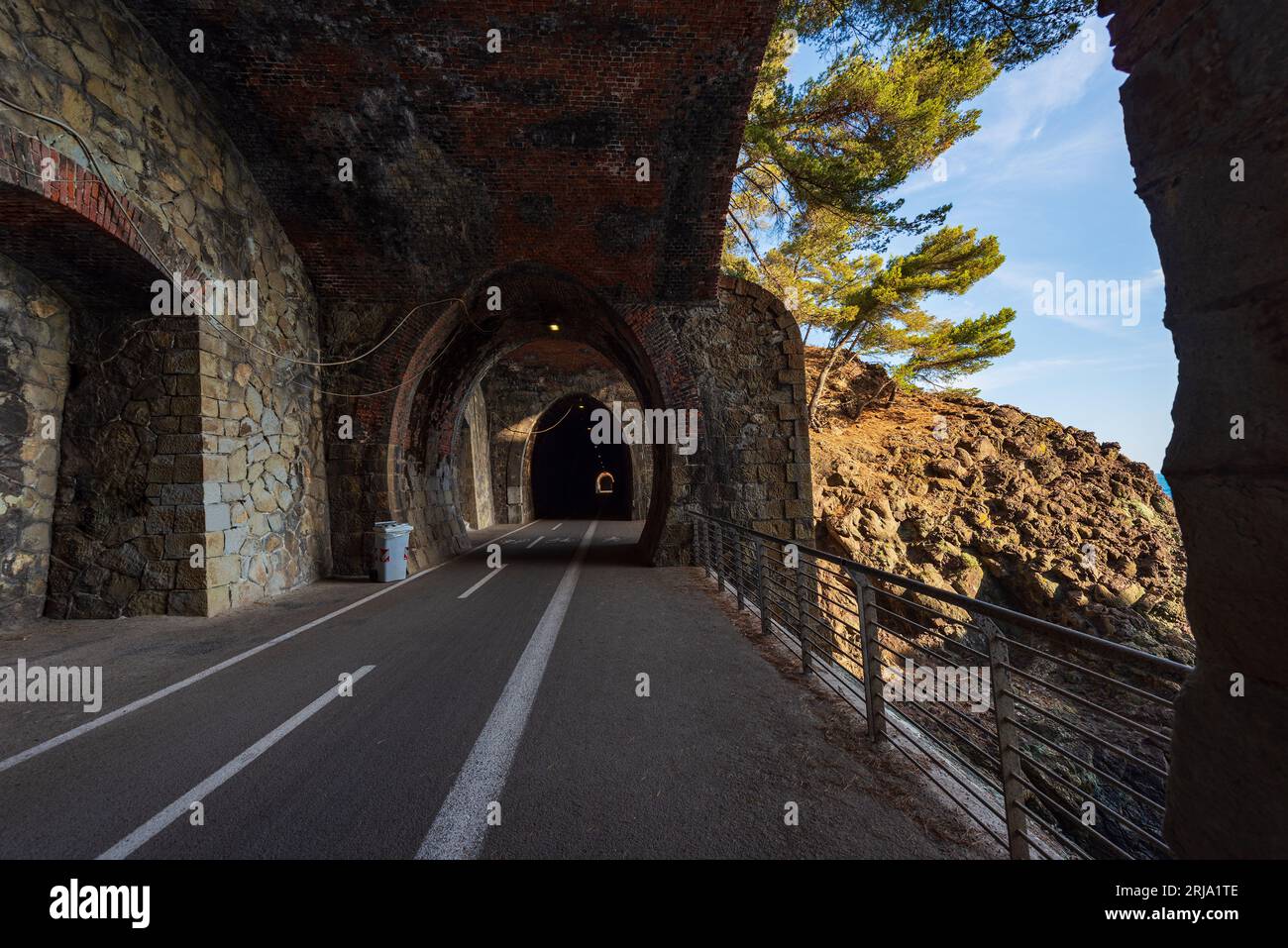 Percorso ciclabile e pedonale all'interno di un vecchio tunnel ferroviario in disuso. La strada collega i tre paesi di Levanto, Bonassola e Framura, Liguria. Foto Stock