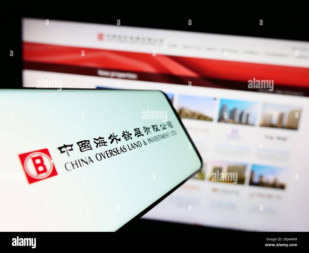 Smartphone con logo China Overseas Land and Investment Limited (COLI) sullo schermo davanti al sito Web. Concentrarsi sul centro del display del telefono. Foto Stock