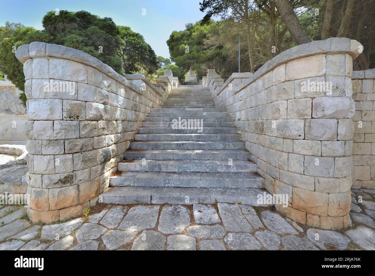 Scalini di pietra di uno straicase all'aperto che sale molto in alto in un parco della Puglia in Italia Foto Stock