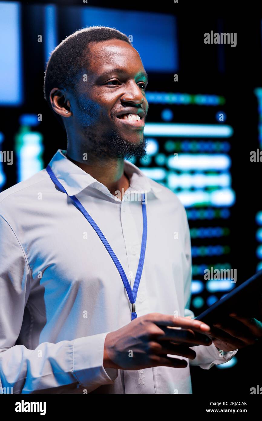 Tecnico che esegue i cluster di server test diagnostici e utilità di controllo degli errori per determinare e risolvere i problemi software. Ingegnere che esamina i sistemi critici, verificando la presenza di guasti utilizzando un tablet Foto Stock