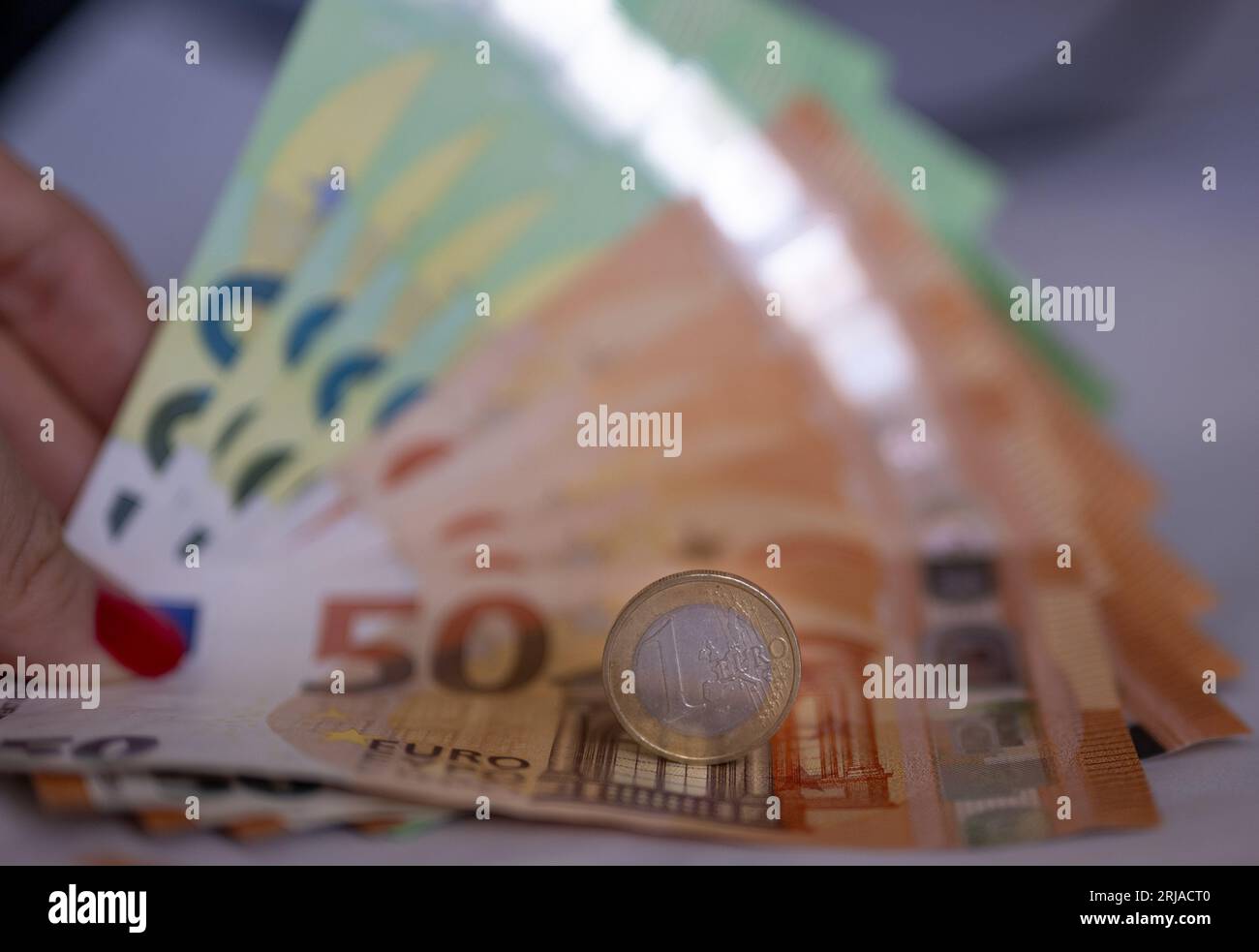 Berlino, Germania. 21 agosto 2023. Una donna ha in mano banconote del valore di 100 e 50 euro. Una moneta da 1 euro si trova sopra le banconote. Crediti: Monika Skolimowska/dpa/Alamy Live News Foto Stock