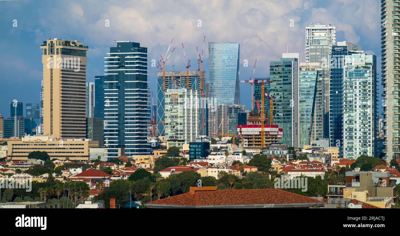 Incredibile paesaggio urbano con moderni edifici a più piani e grattacieli di vetro contro il cielo blu nuvoloso a Tel Aviv in Israele Foto Stock