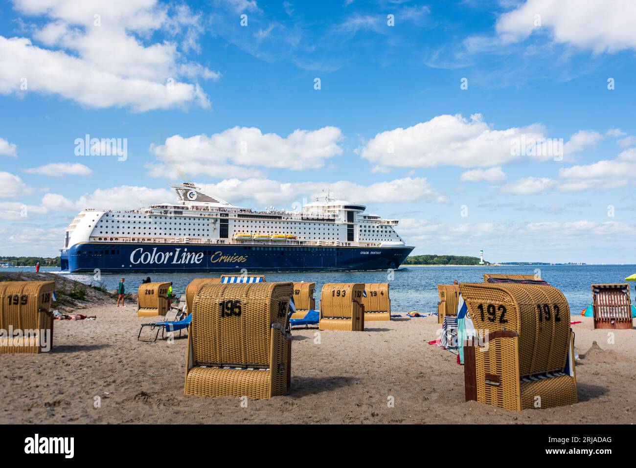 Sommer Strandleben mit Strandkörben an der Kieler Förde in Möltenort, Die Maxi Fähre Color Fantasy fährt vorbei Foto Stock