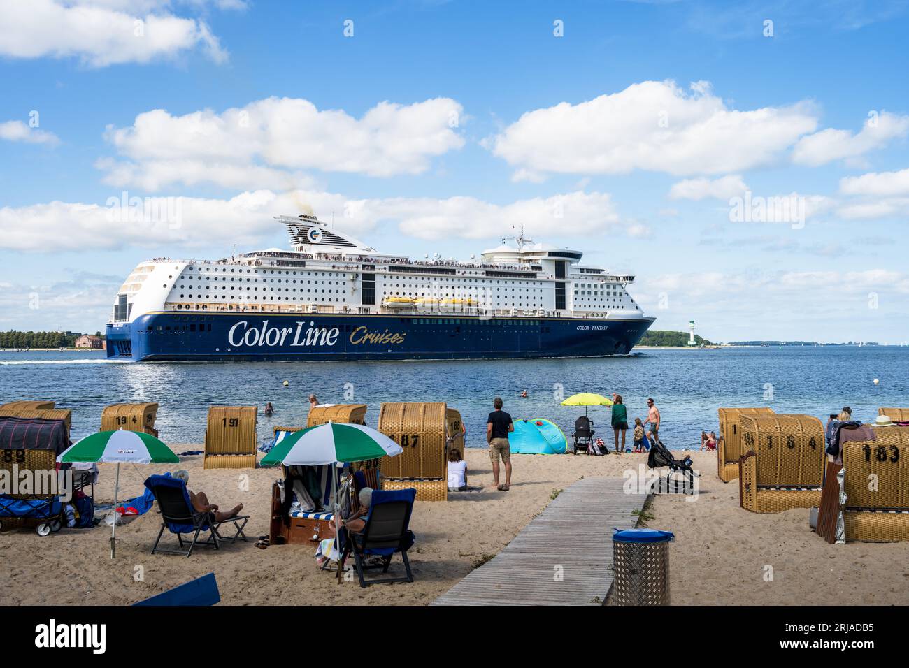 Sommer Strandleben mit Strandkörben an der Kieler Förde in Möltenort, Die Maxi Fähre Color Fantasy fährt vorbei Foto Stock