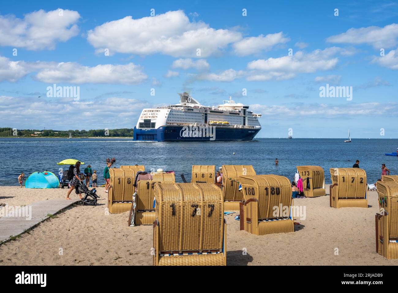 Sommer Strandleben mit Strandkörben an der Kieler Förde in Möltenort, Die Maxi Fähre Color Fantasy fährt vorbei Foto Stock