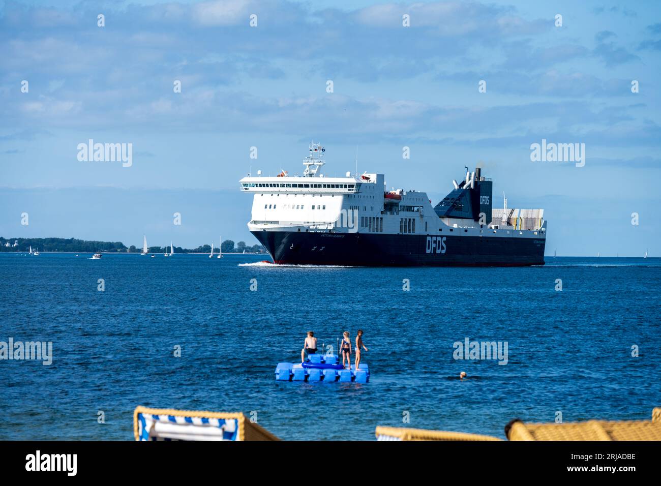 Sommer Strandleben mit Strandkörben an der Kieler Förde in Möltenort, Die Maxi Fähre Victoria Seaways fährt vorbei Foto Stock