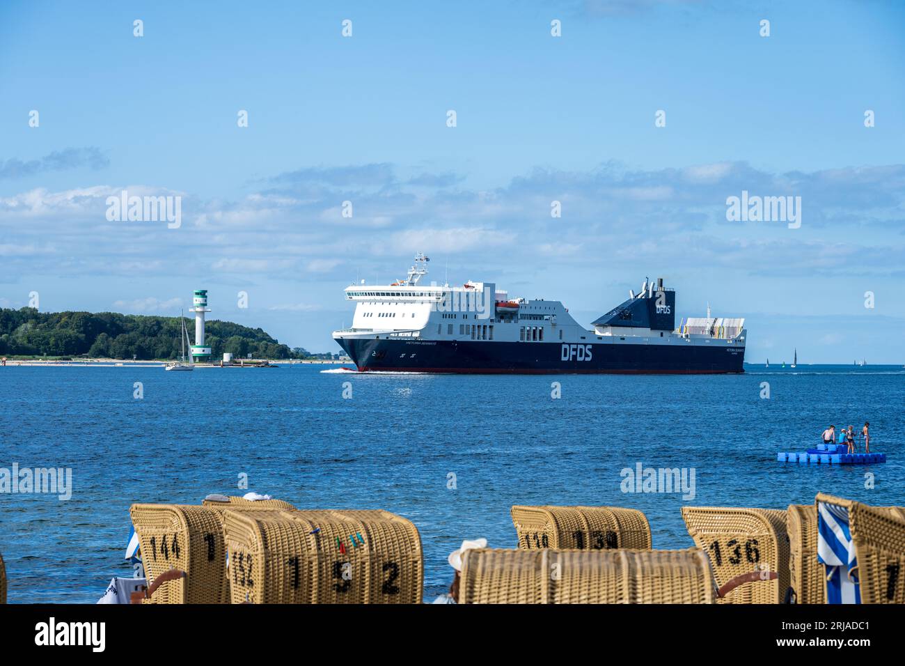 Sommer Strandleben mit Strandkörben an der Kieler Förde in Möltenort, Die Maxi Fähre Victoria Seaways fährt vorbei Foto Stock