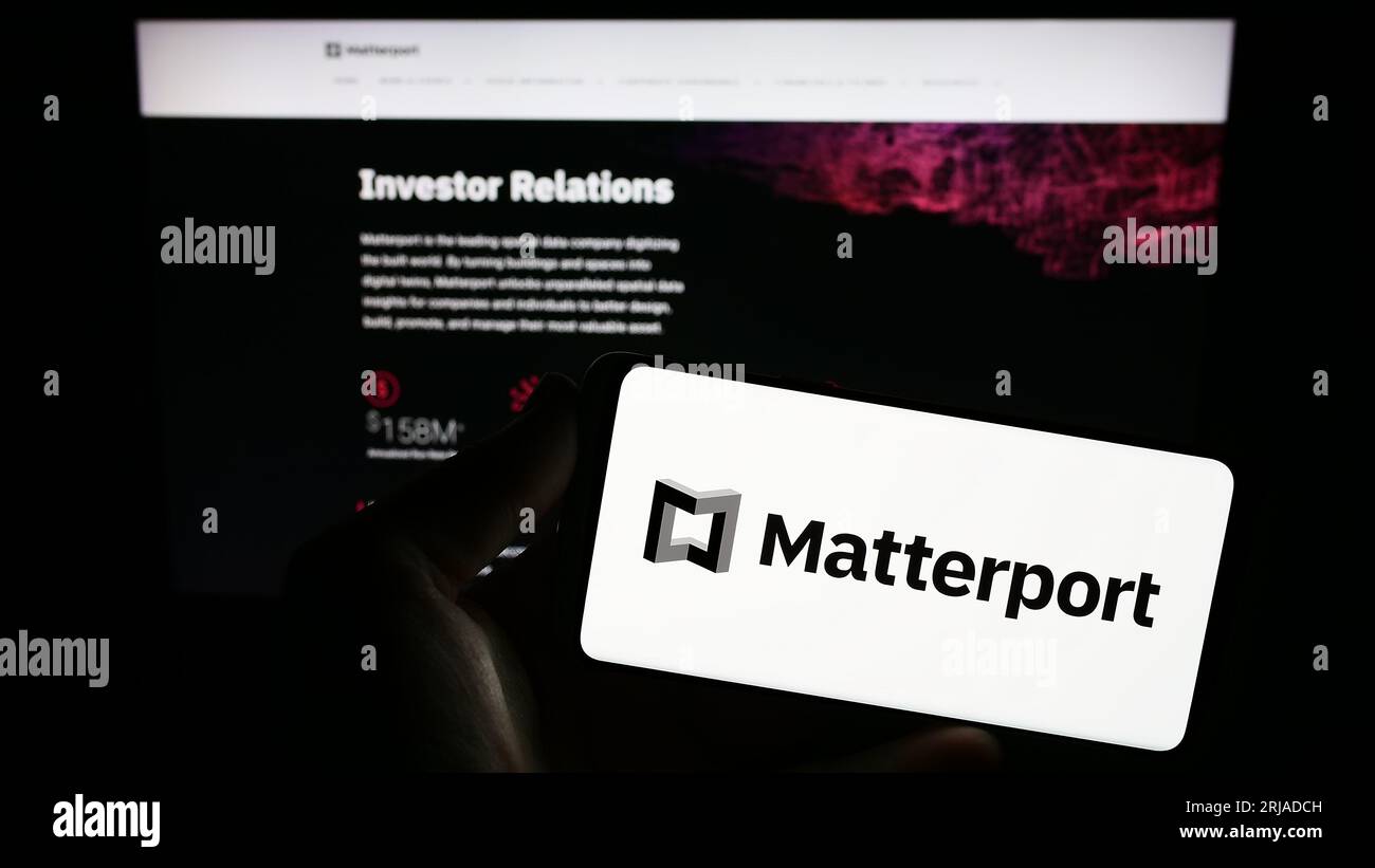 Persona che possiede un telefono cellulare con il logo della società di software immobiliare statunitense Matterport Inc. Sullo schermo davanti alla pagina Web. Concentrarsi sul display del telefono. Foto Stock