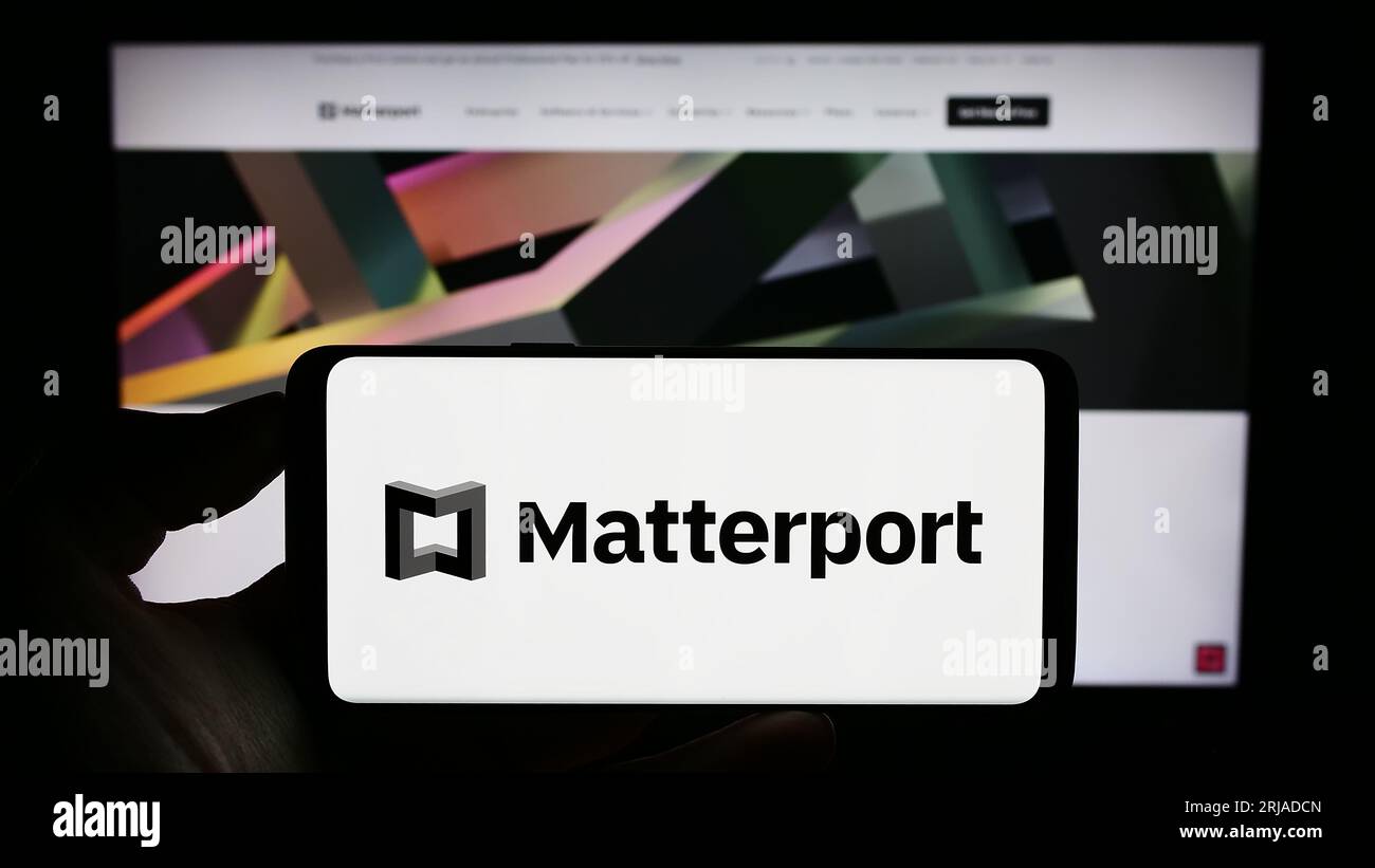 Persona che possiede uno smartphone con il logo della società di software immobiliare statunitense Matterport Inc. Sullo schermo di fronte al sito Web. Concentrarsi sul display del telefono. Foto Stock