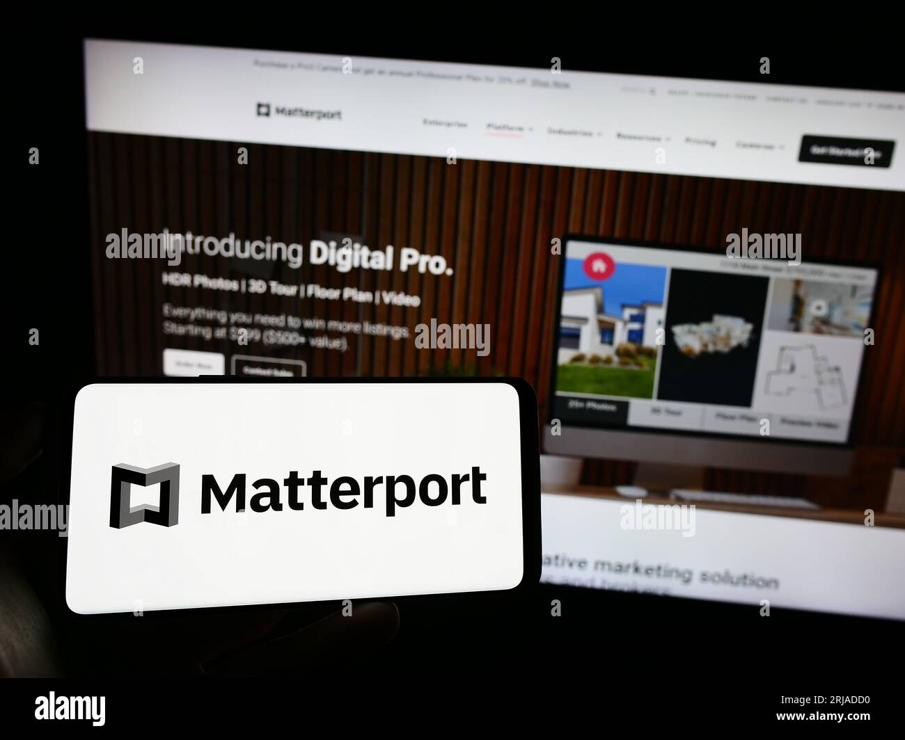 Persona che possiede il cellulare con il logo della società di software immobiliare statunitense Matterport Inc. Sullo schermo davanti alla pagina Web. Concentrarsi sul display del telefono. Foto Stock